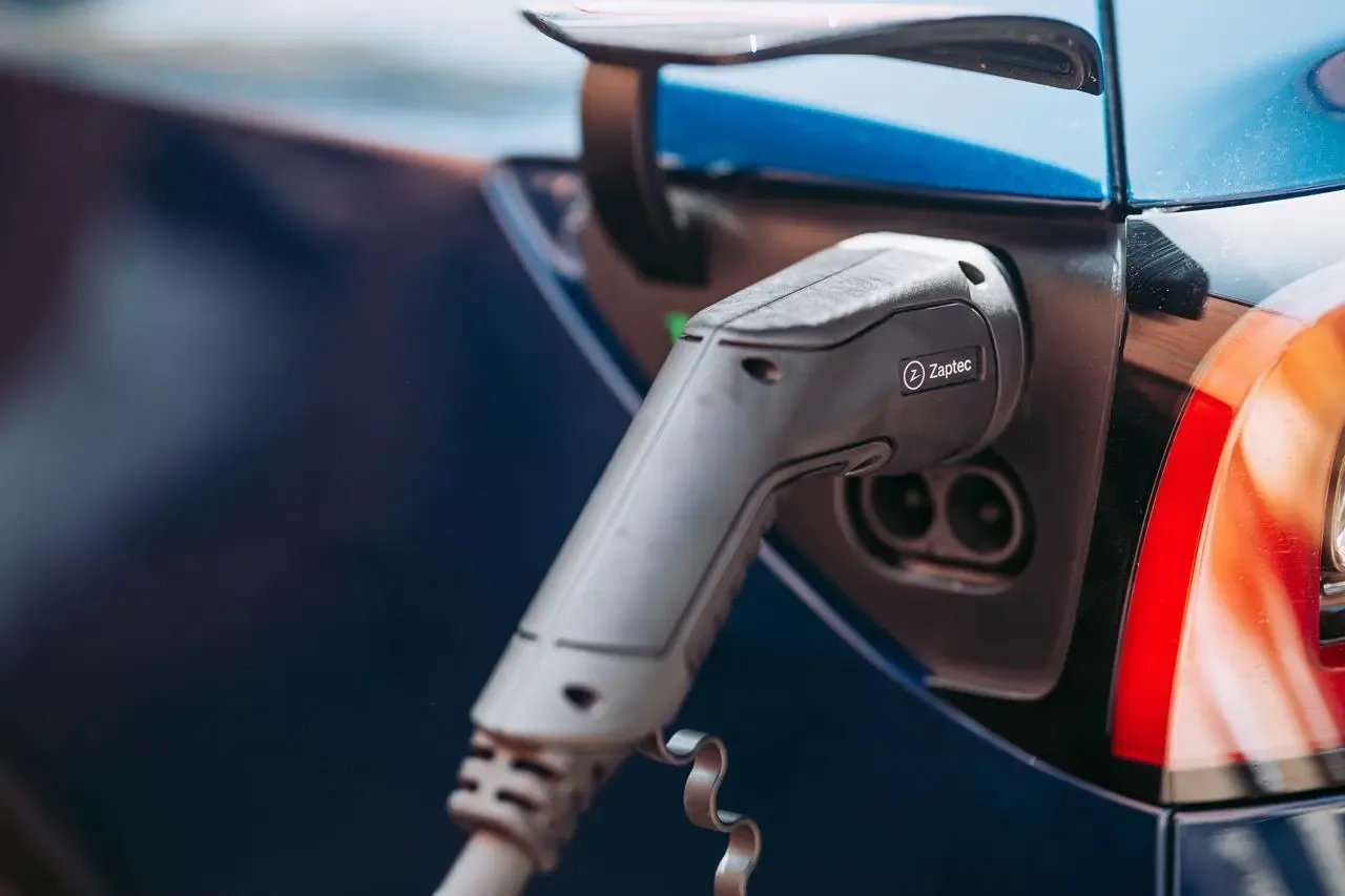 Nærbilde av Zaptec-ladekabel koblet til ladeuttaket på en blå elbil.