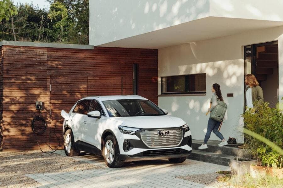 Eine Frau läuft zu ihrem Elektroauto
