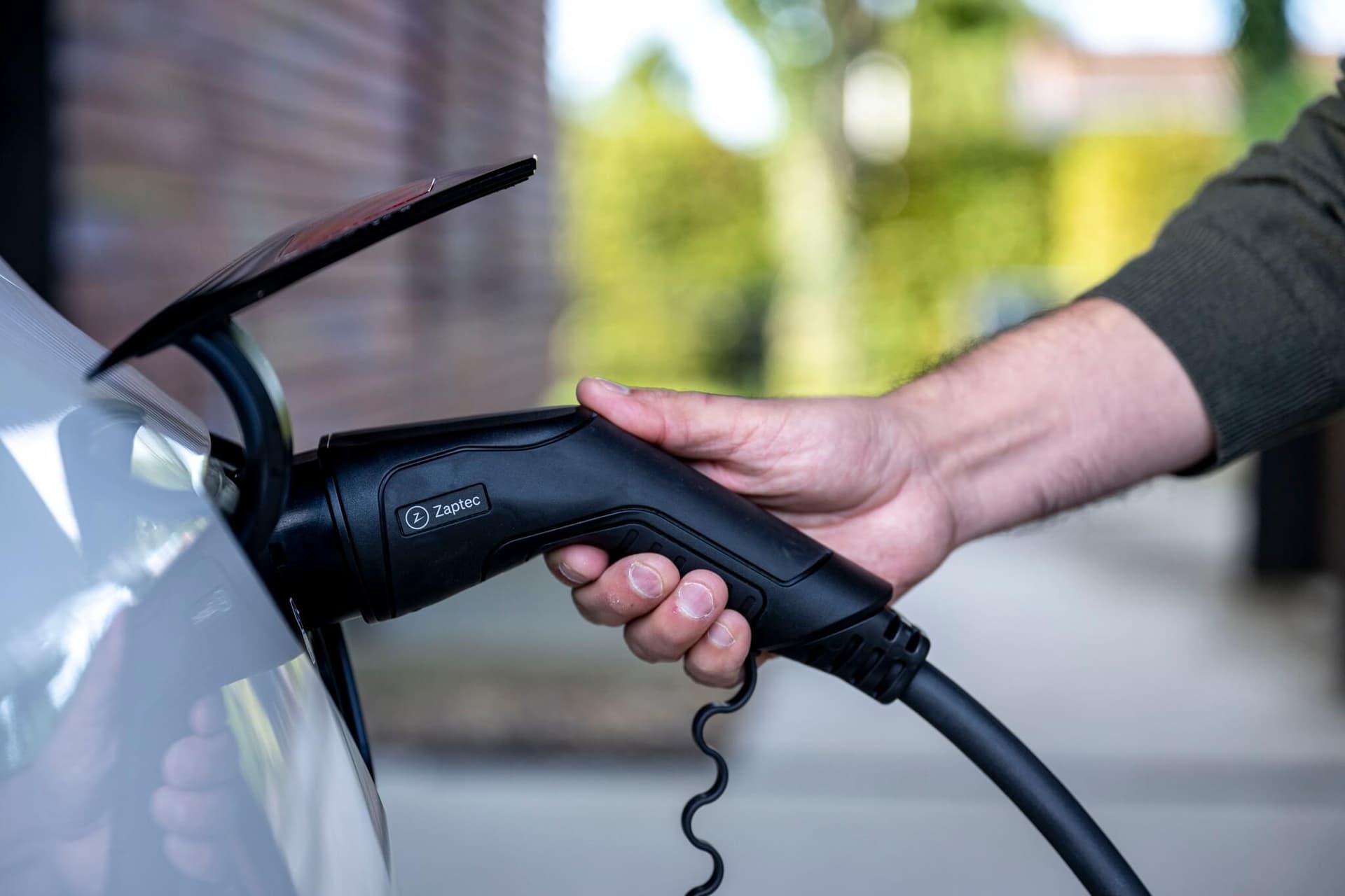 Ein E-Auto mit Rekuperation wird über ein Ladekabel aufgeladen