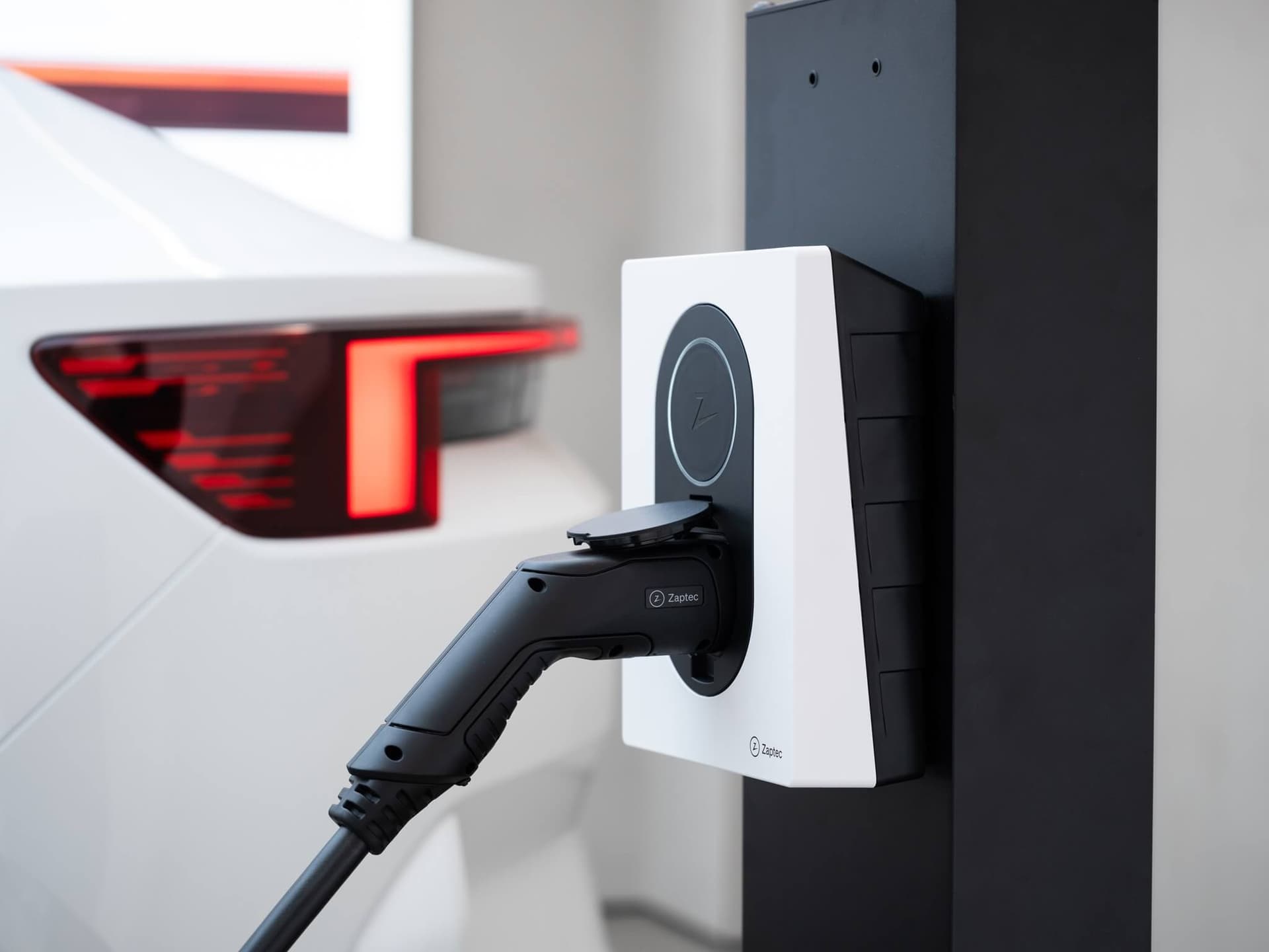 Eine Zaptec Wallbox, die mit Kabel ein Auto lädt