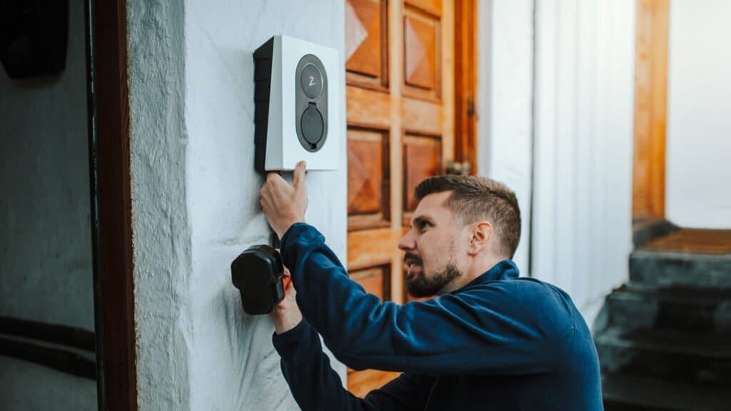 Mann installiert eine Wallbox mit PV-Überschuss-Funktion