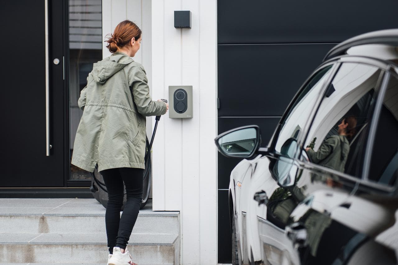 Eine Frau lädt ihr E-Auto an einer AC-Ladestation