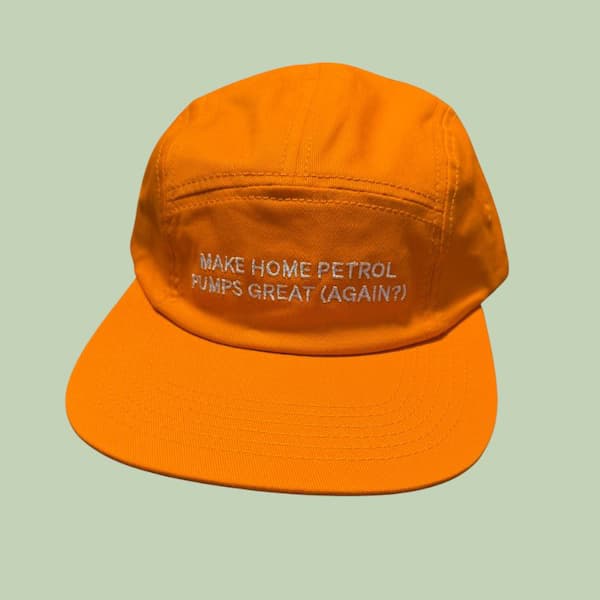 Bright orange cap with embroidered text 'MAKE HOME PETROL PUMPS GREAT (AGAIN?)'