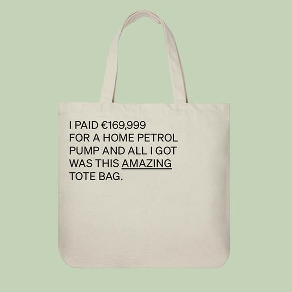 Beige tote bag with black text 'I PAID €169,999 FOR A HOME PETROL PUMP AND ALL I GOT WAS THIS AMAZING TOTE BAG.'