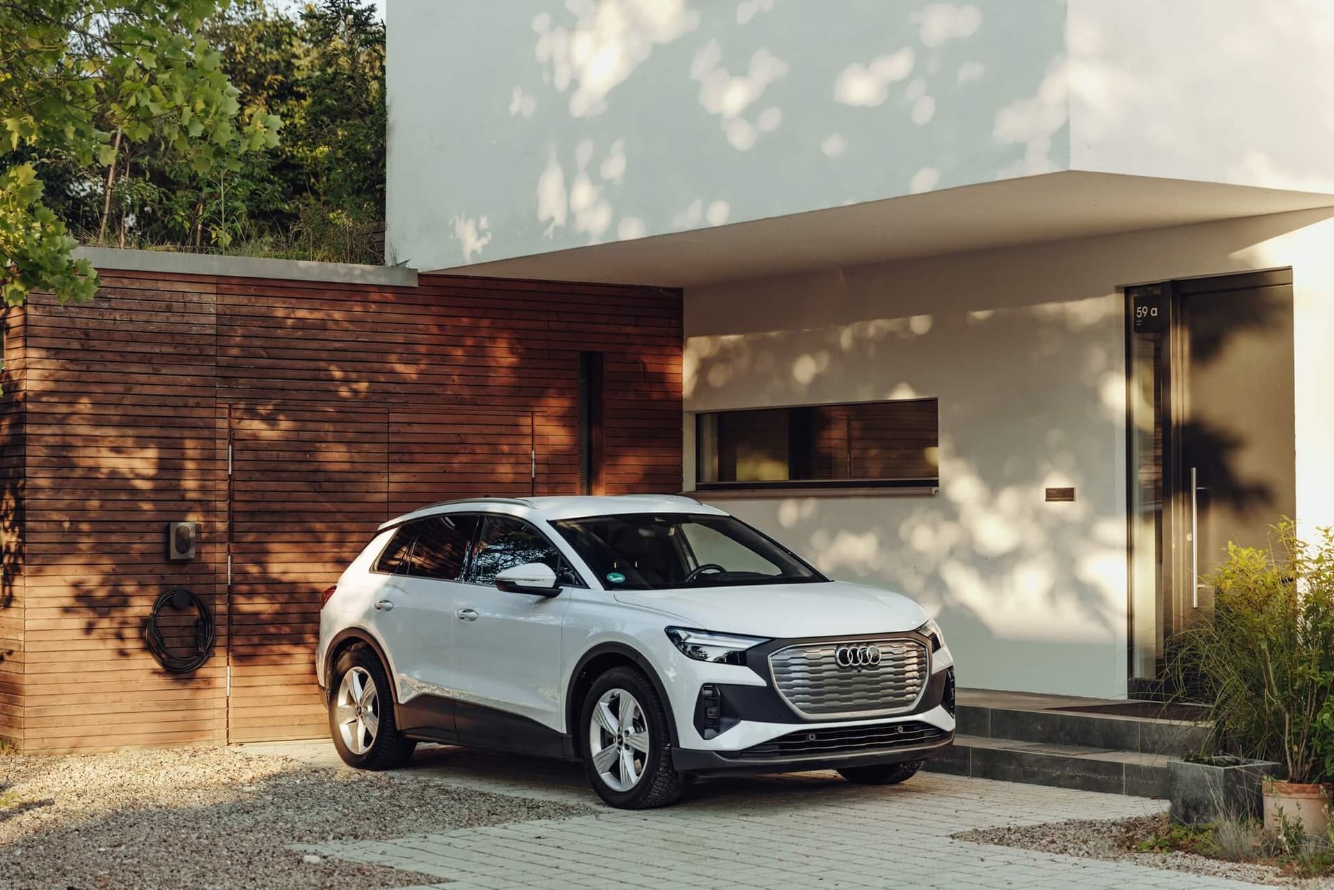 Ein E-Auto mit Rekuperation steht vor einem Haus