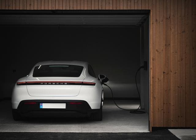 En vit porsche har en Zaptec Go elbilsladdare inkopplad i sig.