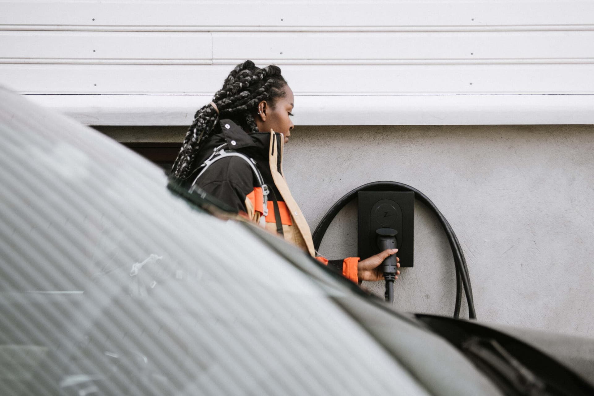 Eine Frau lädt ihr Elektroauto an einer Heimladestation