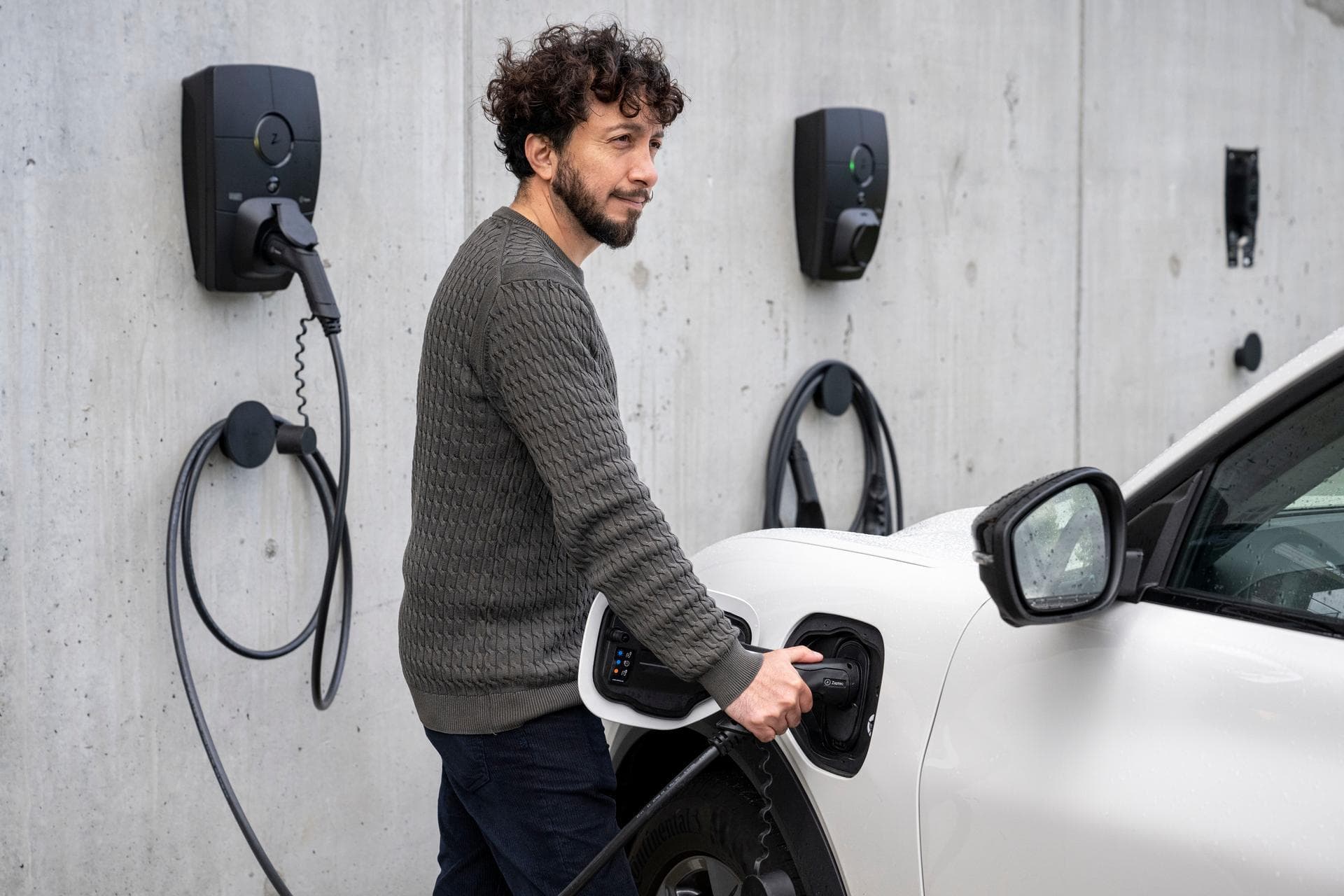 Ein Mann lädt sein E-Auto an einer Ladelösung für Mehrfamilienhäuser.
