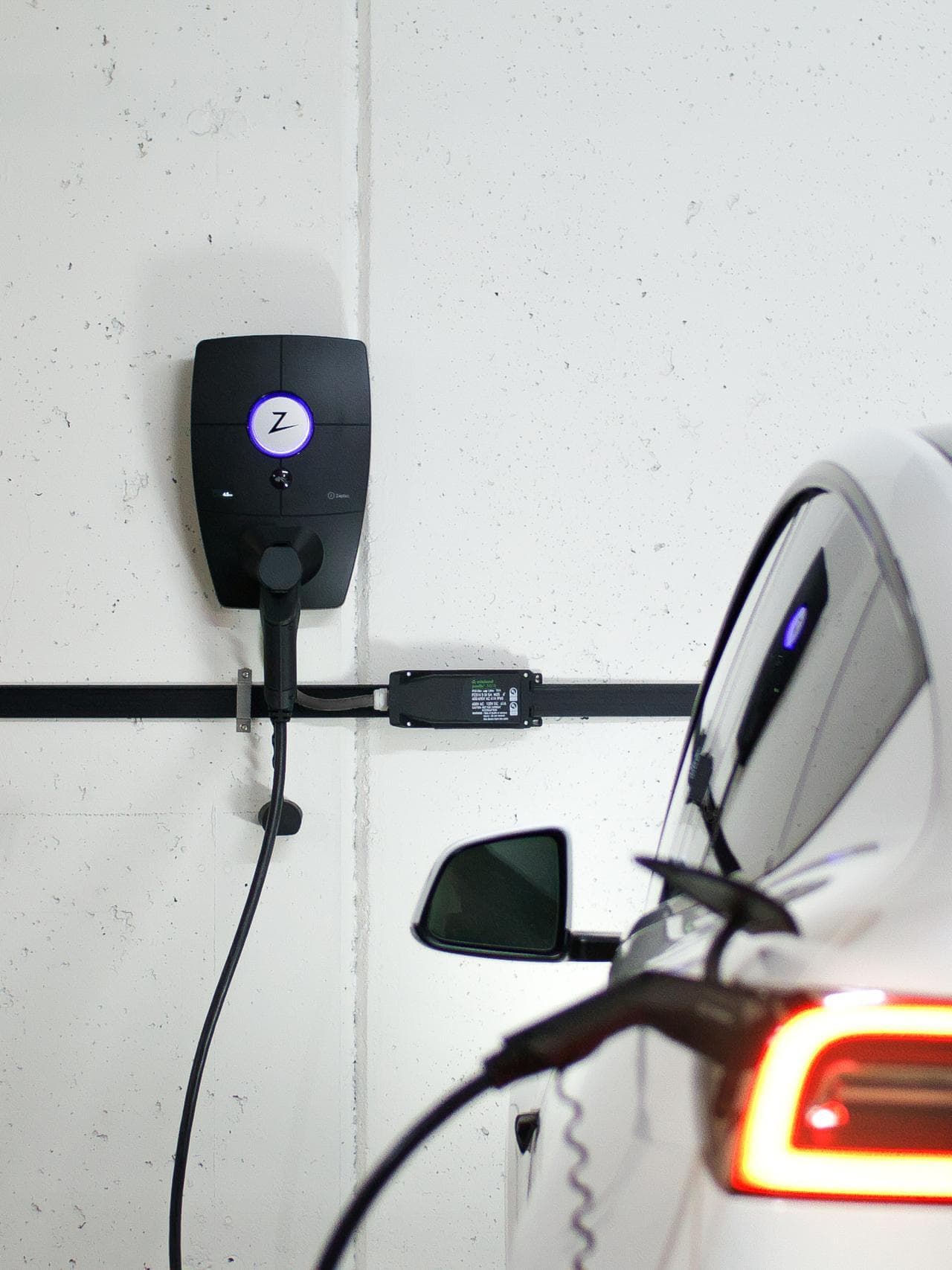 Ein Auto lädt an einer Wallbox in einem Mehrfamilien-Parkhaus